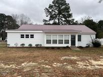 Charming single-story home featuring a metal roof, light-colored siding and a well-maintained lawn at 102 Sue Ave, Dunn, NC 28334