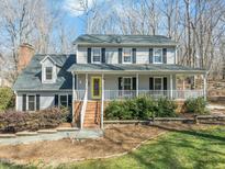 Charming two-story home with a welcoming front porch and professionally landscaped yard at 11424 Horsemans Trl, Raleigh, NC 27613