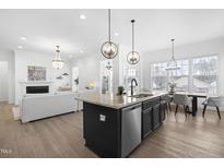 Bright, open kitchen features a central island, stainless steel appliances, and a seamless flow to the dining area at 124 Ferrell W Rd, Apex, NC 27523