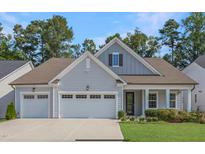 Charming home with a two-car garage, well-manicured lawn and mature trees, offering curb appeal at 163 English Violet Lane Ln, Raleigh, NC 27610