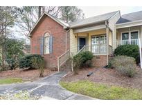 Charming townhouse featuring a brick facade, complemented by a well-manicured lawn and inviting front entry at 18 Kings Mount Ct, Durham, NC 27713