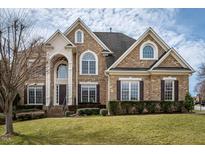 Stately brick home with arched windows and grand entrance, set on a well-manicured lawn at 2000 Falls Farm Crossing Xing, Raleigh, NC 27614