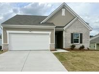 Charming one-story home with brick and vinyl siding, a two-car garage, and a well-manicured lawn at 209 Swift Park Dr, Zebulon, NC 27597