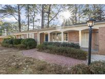 Charming brick home featuring a welcoming walkway, manicured bushes and a cozy covered front porch at 2201 Knollwood Dr, Sanford, NC 27330