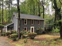 Charming two-story home featuring gray siding, red shutters, well-manicured landscaping, and a backdrop of lush trees at 2301 Pastille Ln, Raleigh, NC 27612
