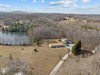Sprawling property featuring a charming home, large shop, shed, and waterfront access on a tranquil lake at 341 Acorn Ct, Rougemont, NC 27572