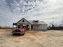 Exterior view of a single-story home under construction, featuring a red truck in front at 40 Bailey-Boykin Rd, Selma, NC 27576