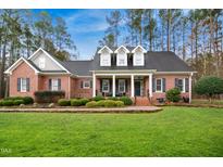 Charming brick home with well-manicured lawn, mature trees, and welcoming front porch at 5300 Grand Gate Dr, Raleigh, NC 27613