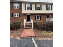 Charming brick townhouse with black shutters and a welcoming entryway staircase at 6102 Highcastle Ct, Raleigh, NC 27613