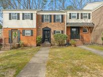 Charming townhomes featuring brick facades, black shutters, and well-maintained landscaping at 6469 New Market Way, Raleigh, NC 27615