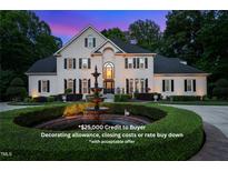 Stunning two-story brick home featuring a circular driveway with fountain and lush landscaping at 9936 Koupela Dr, Raleigh, NC 27614