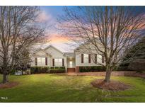 Charming home featuring a manicured lawn, mature trees and inviting front porch at 1212 Red Brick Rd, Garner, NC 27529