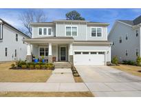 Charming two-story home with a welcoming front porch, stone accents, and a two-car garage at 1213 Remey Ave, Wake Forest, NC 27587