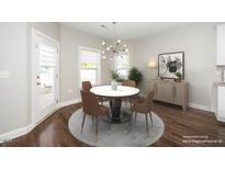 Bright dining room features a modern chandelier, a round table with seating, and lots of natural light at 141 W Falcon Ct., Clayton, NC 27520
