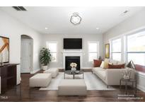 Bright living room featuring a fireplace, decorative lighting, and comfortable seating arrangement at 141 W Falcon Ct., Clayton, NC 27520