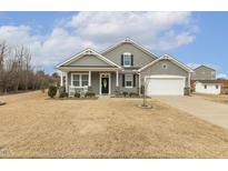 Charming single-Gathering home with a well-manicured lawn and rocking chairs on the front porch at 149 Brickhouse Ln, Fuquay Varina, NC 27526