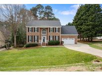 Charming two-story brick home with manicured lawn and attached two-car garage at 1716 Turtle Ridge Way, Raleigh, NC 27614