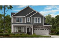 Charming two-story home with stone accents, a two-car garage, and a beautifully landscaped front yard at 201 Hiddenite Pl, Holly Springs, NC 27540