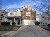 Charming two-story home features a stone facade, two car garage and inviting front porch at 2015 Tennessee Road Rd, Durham, NC 27704