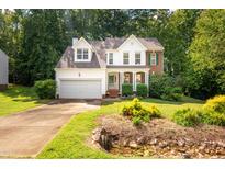 Charming home featuring a landscaped front yard, attached garage, and classic architectural details at 2310 Woodbury Dr, Hillsborough, NC 27278