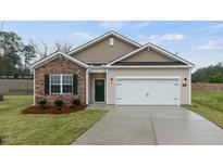 Charming home featuring stone accents, a two-car garage and a beautifully landscaped front yard at 2566 Summersby Dr, Mebane, NC 27302