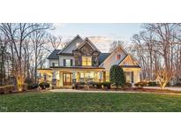 Beautiful two-story home with stone accents and a covered front porch, surrounded by mature trees and a lush lawn at 2617 Jones Ferry Rd, Chapel Hill, NC 27516