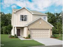 Charming two-story home featuring a brick-accented facade, a two-car garage, and beautifully landscaped front yard at 308 Arch Canyon Cir, Zebulon, NC 27597