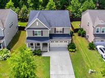 Charming two-story home with a well-manicured lawn and a spacious two-car garage at 428 Morgan Ridge Rd, Holly Springs, NC 27540