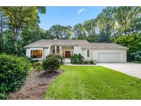 Charming single-story home with manicured lawn, mature trees, and attached garage at 4332 Blossom Hill Ct, Raleigh, NC 27613