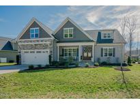 Charming two-story home with well-manicured lawn and attached two-car garage at 65 Walking Trl, Youngsville, NC 27596