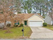 Charming single-Gathering home featuring stone accents, green door, attached garage, and well-maintained lawn at 7 Windsor Glen Dr, Durham, NC 27703