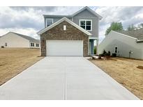 Two-story home featuring a spacious garage, driveway, and nicely contrasted neutral-colored siding at 801 Berkeley Glen Rd, Zebulon, NC 27597