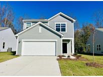 Two-story home featuring a two-car garage, craftsman-style door, and lovely landscaping at 801 Berkeley Glen Rd, Zebulon, NC 27597
