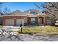 Charming brick home featuring an attached two-car garage, manicured lawn, and classic architectural details at 9413 Lake Villa Way, Raleigh, NC 27614