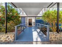 Inviting entrance featuring a covered walkway, colorful landscaping, and modern railings leading to the front door at 1004 Kings Mill Rd, Chapel Hill, NC 27517