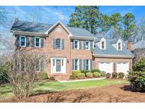 Charming brick home with manicured lawn, two-car garage and inviting entryway at 104 Buckden Pl, Cary, NC 27518