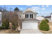 Charming home featuring a two-car garage with stone accents and classic architectural details at 108 Wagon Tie Ln, Garner, NC 27529