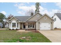 Charming one-story home featuring a well-maintained front yard and a convenient attached garage at 11228 N Radner Way, Raleigh, NC 27613
