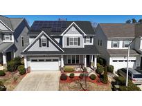 Charming two-story home with a well-manicured lawn, solar panels, and an attached garage at 2132 Royal Berry Ct, Cary, NC 27511
