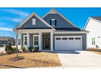 Charming, traditional-style home featuring a two-car garage, blue siding, and a welcoming front porch at 276 Bevis Marks Dr, Fuquay Varina, NC 27526
