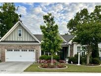 Charming single-story home featuring a two-car garage and beautifully landscaped front yard with colorful flower beds at 2851 Wilkes Lake Dr, Fuquay Varina, NC 27526
