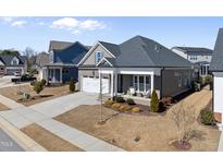 Charming home featuring an attached two-car garage, covered porch and manicured lawn and landscape at 2907 Jakes View Pt, Fuquay Varina, NC 27526