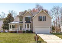 Charming two-story home with manicured lawn, attached garage, and inviting front porch at 3003 Cregler Dr, Apex, NC 27502
