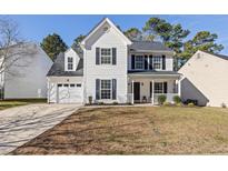 Charming two-story home with a well-manicured lawn, attached garage, and covered front porch in a residential neighborhood at 308 Arbor Crest Rd, Holly Springs, NC 27540
