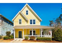 Charming yellow two-story home with a covered porch, white railings, and manicured landscaping at 314 Tobacco Farm Way, Chapel Hill, NC 27516