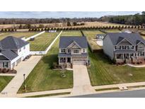 An aerial view of a two-story home with a manicured lawn and a paved driveway, nestled in a suburban neighborhood at 319 Brinkley Cir, Mebane, NC 27302