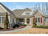 Charming home featuring a stone facade, inviting porch, and well-manicured landscaping at 363 Rolling Meadows Ln, Chapel Hill, NC 27517
