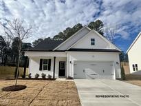Charming new construction home featuring a two-car garage, craftsman-style details, and a well-manicured front lawn at 394 Springtooth Dr, Zebulon, NC 27597