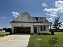 Charming single-story home with white siding, black trim, and an attached two-car garage at 394 Springtooth Dr, Zebulon, NC 27597