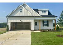 Charming single-story home featuring a two-car garage and well-maintained front lawn at 394 Springtooth Dr, Zebulon, NC 27597